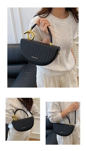 Detail of black woven saddle bag with gold metal ring handle and V-texture finish