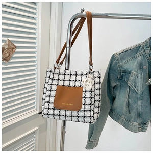 Houndstooth tote bag with brown leather pocket and a cute white cat keychain charm