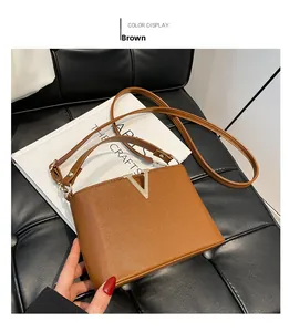 Detailed view of brown lychee grain leather bucket bag with gold V-metal decor