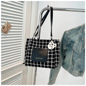 Minimalist black and white tweed tote bag with leather pocket and white cat charm