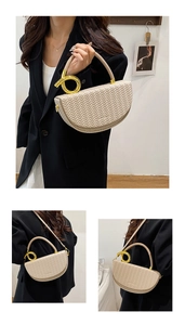 Detailed view of beige saddle bag with woven texture and gold circular handle ring