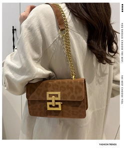 Detail view of the brown leopard print crossbody bag with gold chain and metal buckle
