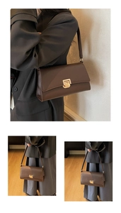 Detail of dark brown leather underarm bag featuring a minimalist gold square metal clasp