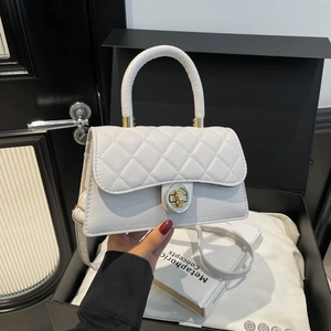 White quilted crossbody bag with golden twist lock shown in a luxury lifestyle setting