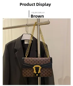 Close-up of brown vintage handbag with M-pattern print and gold horsebit buckle