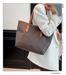Detail of vintage monogram tote bag with leather straps and golden rivet hardware