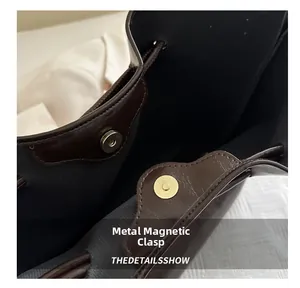 Dettaglio della chiusura magnetica dorata su una borsa tote in pelle marrone