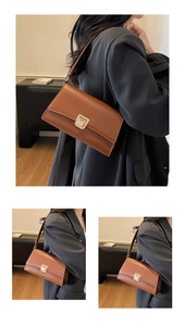 Detail of classic brown leather shoulder bag featuring a sleek golden square buckle lock
