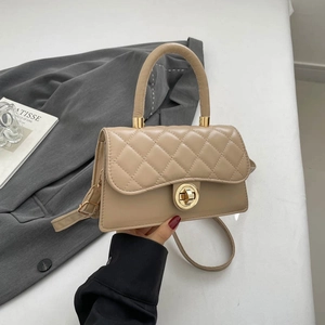 Beige quilted handbag with golden twist lock and single handle shown from 45-degree angle