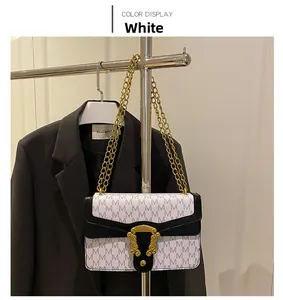 Detail view of white chain shoulder bag with M pattern print hanging on a metal rack