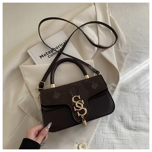 Detail of snake pattern flap and gold metal S-buckle on a brown leather handbag