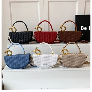 Multiple colors of woven saddle bags featuring a twisted gold metal handle display