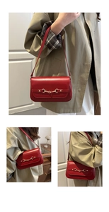 Macro shot of deep red leather shoulder bag featuring an elegant golden horsebit buckle