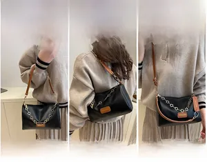 Détail du sac polochon noir en cuir montrant les styles porté main, épaule et croisé