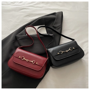 Close-up of minimalist crossbody bags with gold horsebit buckle and sleek flap design