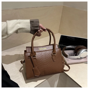 Close-up of brown faux leather bag with animal texture and golden logo detail