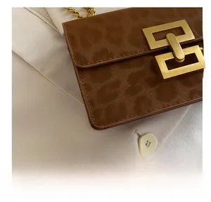 Detailed close-up of leopard print crossbody bag with premium matte gold hardware