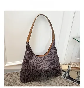 Detailed view of leopard print hobo bag with brown leather straps and spacious interior