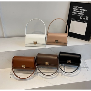 Detail view of five minimalist underarm bags in various colors on a tiered display