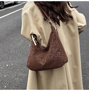 Close-up of leopard print hobo bag with suede texture and stylish beaded tassel charm