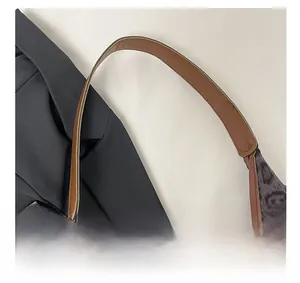 Detailed macro view of animal print fabric texture and premium brown leather handle