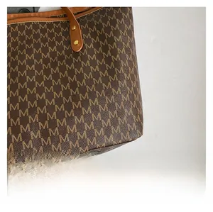 Close-up of retro printed letter pattern and leather trim on a large tote bag