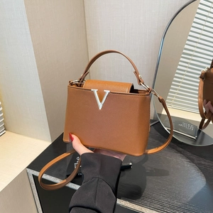 Brown lychee leather bucket bag with silver V-shaped hardware and dual handles