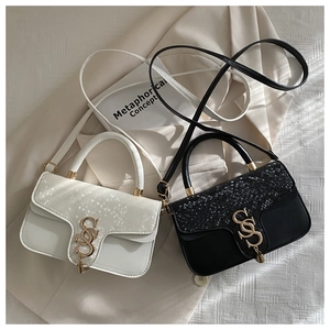Close-up of dual-color small square bags featuring glossy snakeskin texture and gold S logo