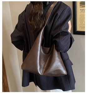 Detail of minimalist dark brown leather tote bag with Fashion Classic Leather embossed logo