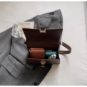 Interior storage view of dark brown baguette bag with wallet, phone and cosmetics