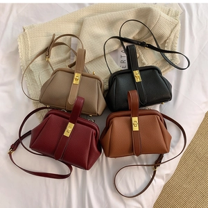 Flat lay of vintage doctor bags in khaki, black, burgundy, and brown with gold hardware