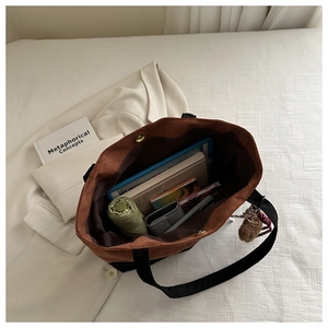 Detalle interior del bolso tote bicolor con amplio almacenamiento para accesorios