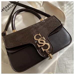 Close-up of deep brown shoulder bag featuring snake-print leather and gold metal logo