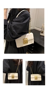 Detail view of white leather chain bag with golden interlocking clasp and leopard pattern
