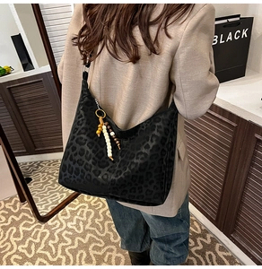 Close-up of leopard print tote bag with beaded tassel detail on matte texture