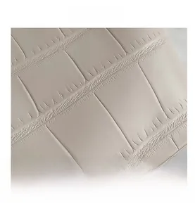 Close-up of the elegant cream crocodile embossed leather texture on a shoulder tote bag