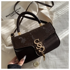 Macro detail of snake skin texture and gold interlocking logo on brown crossbody bag