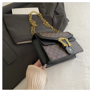 Close-up of vintage flap bag showing embossed gold hardware and monogram pattern details