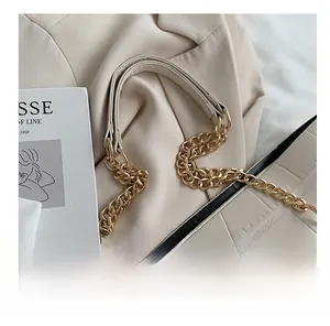Detail of beige tote bag with crocodile texture and chunky gold chain strap