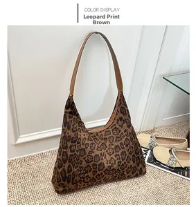 Leopard print tote bag detail with brown leather handles on a woven rug