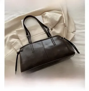 Detail of dark brown leather tote bag with vertical stitching and drawstring accents