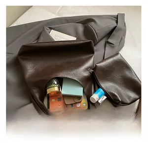 Macro detail of large dark brown tote bag capacity with matching pouch and essentials