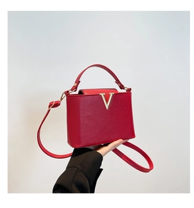 Sac seau rouge chic avec décoration en V dorée et bandoulière amovible réglable