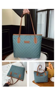 Detail view of dark green quilted tote bag with brown leather handles and brand label