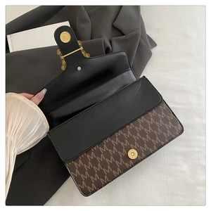 Detail view of the vintage monogram shoulder bag featuring a gold magnetic clasp and inner lining