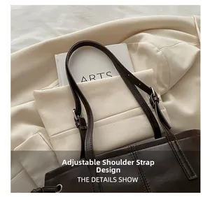 Detail of adjustable shoulder strap with silver metal buckle on brown leather tote bag