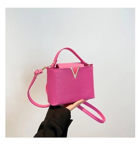 Sac seau rose vif chic avec boucle V dorée et bandoulière amovible élégante