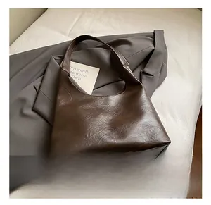 Detail of dark brown leather hobo bag with vintage textured finish and wide shoulder strap