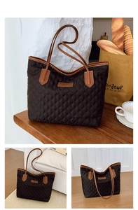 Detail of a black quilted tote bag with brown leather straps in a lifestyle setting