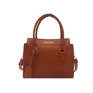Brown crocodile embossed tote bag with top handles and adjustable shoulder strap